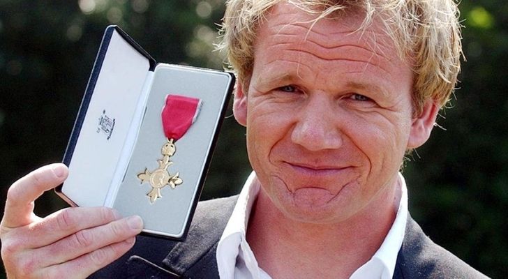 Gordan Ramsay looking proud holding up a medal